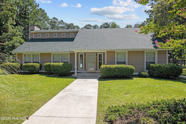 view of front of home with a shingled roof and a front yard