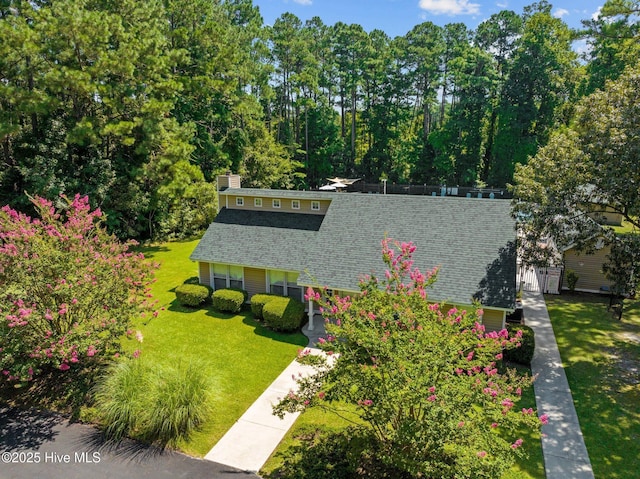 exterior space with roof with shingles, central AC unit, and a front yard