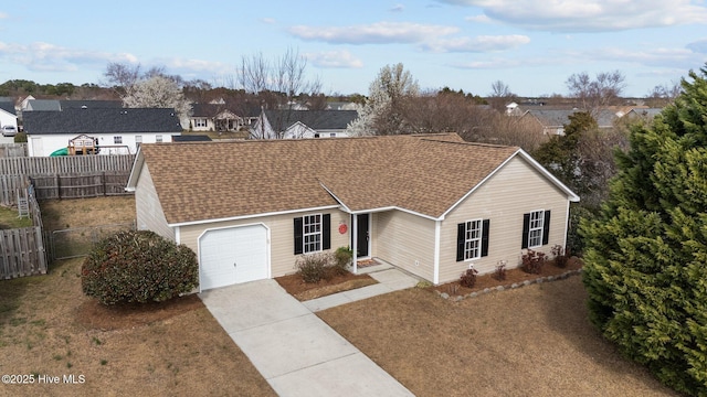 ranch-style house with a shingled roof, concrete driveway, an attached garage, fence, and a residential view