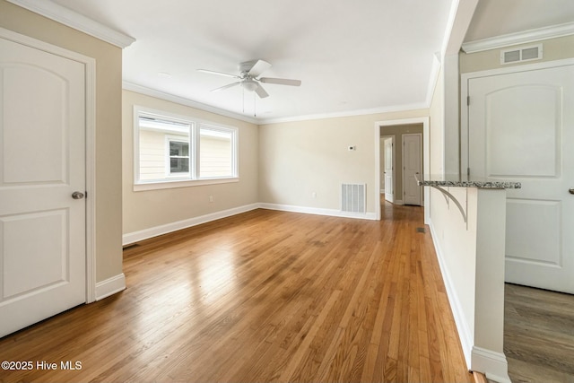 unfurnished room with ceiling fan, ornamental molding, and light hardwood / wood-style floors