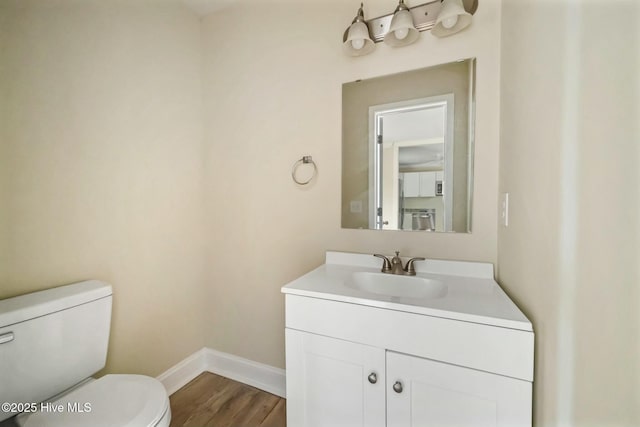 bathroom featuring vanity, wood-type flooring, and toilet