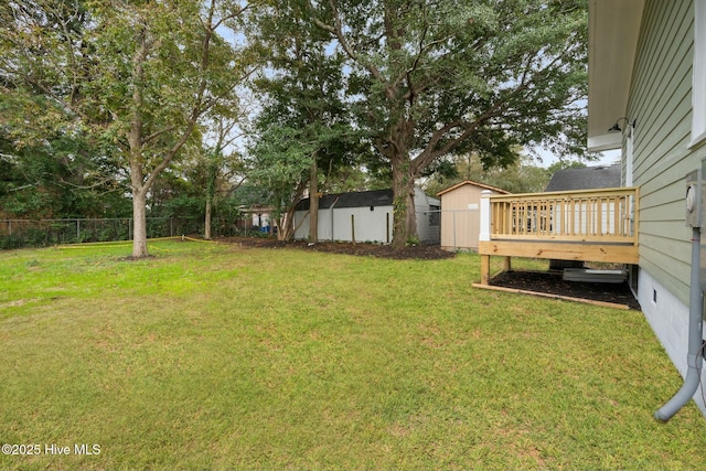 view of yard featuring a deck and a storage unit