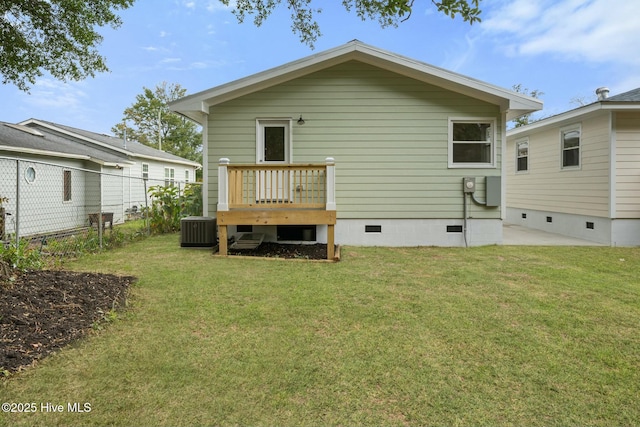 rear view of property featuring a yard and central AC unit