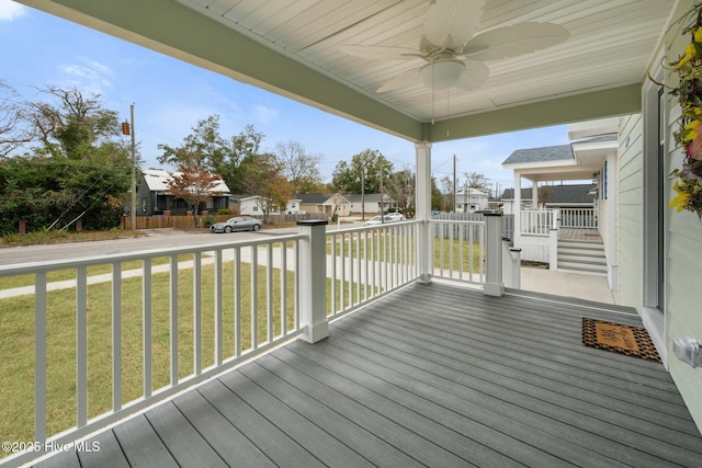 wooden deck with a lawn, ceiling fan, and covered porch