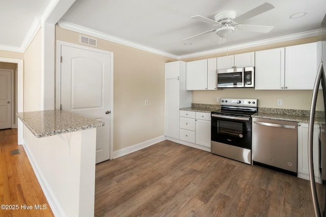 kitchen with a breakfast bar area, white cabinetry, stainless steel appliances, light stone counters, and dark hardwood / wood-style flooring