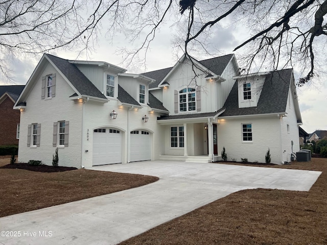 view of front of house with driveway, a shingled roof, an attached garage, and brick siding