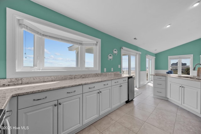 kitchen with white cabinets, sink, and light stone countertops