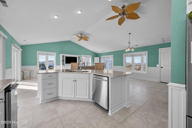 kitchen featuring hanging light fixtures, light stone countertops, stainless steel dishwasher, sink, and white cabinetry