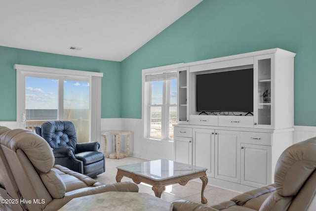 living room featuring lofted ceiling and light tile patterned floors