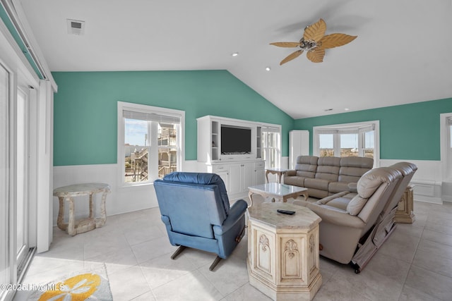 tiled living room featuring ceiling fan, vaulted ceiling, and a wealth of natural light