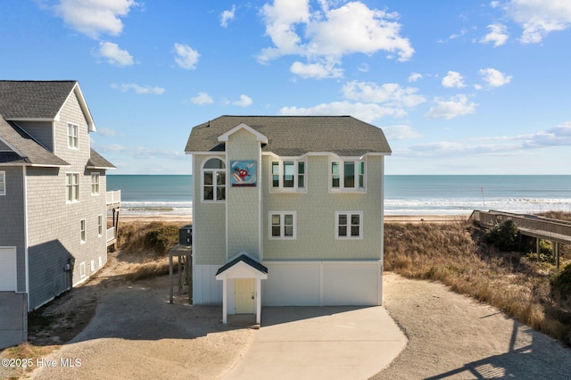 view of outbuilding featuring a water view and a beach view