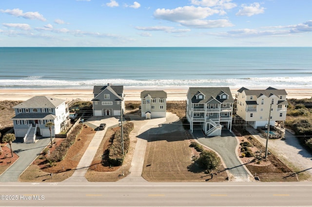 drone / aerial view featuring a water view and a beach view