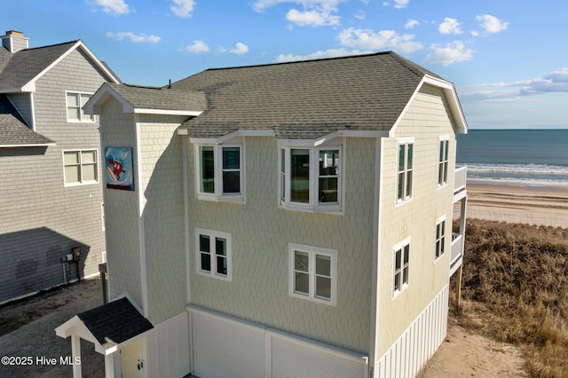 view of side of home with a water view and a view of the beach