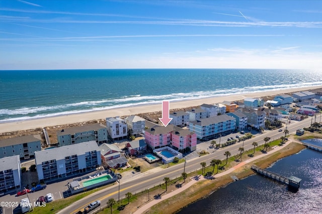 drone / aerial view with a water view and a beach view