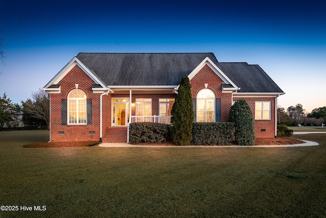 single story home featuring roof with shingles, crawl space, a yard, a porch, and brick siding