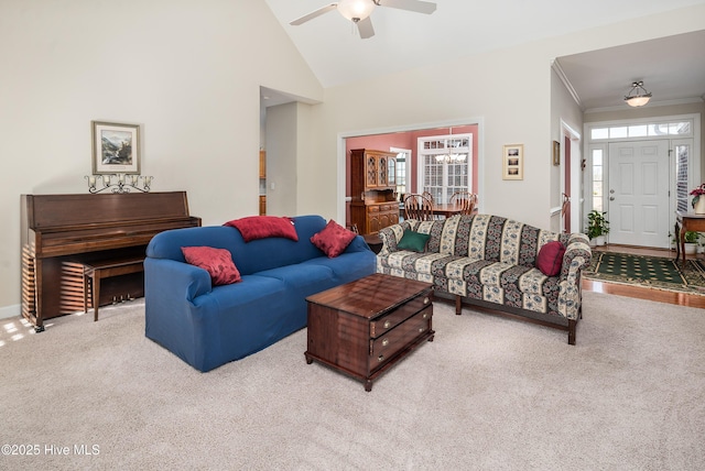 carpeted living area with baseboards, ceiling fan, high vaulted ceiling, and crown molding