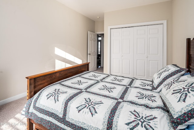 carpeted bedroom featuring a closet and baseboards