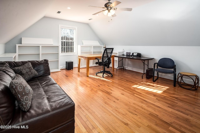 office space featuring lofted ceiling, ceiling fan, wood finished floors, visible vents, and baseboards