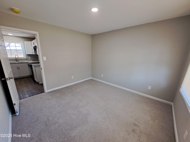 unfurnished bedroom featuring sink and carpet