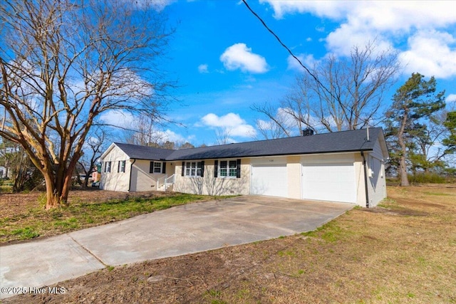 ranch-style house with a front lawn, an attached garage, and driveway