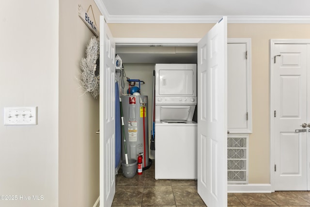 laundry area with crown molding, stacked washer / drying machine, and electric water heater