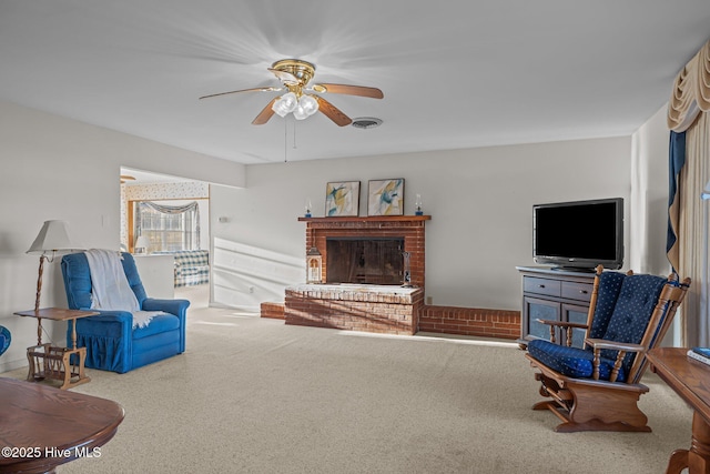 living area with carpet floors, a fireplace, visible vents, and a ceiling fan