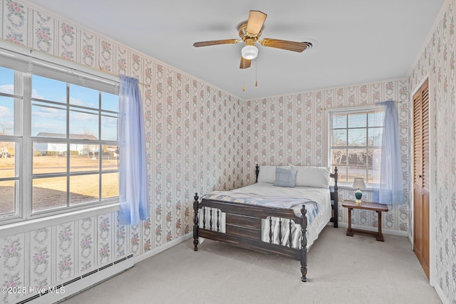 bedroom with wallpapered walls, baseboards, and a baseboard heating unit