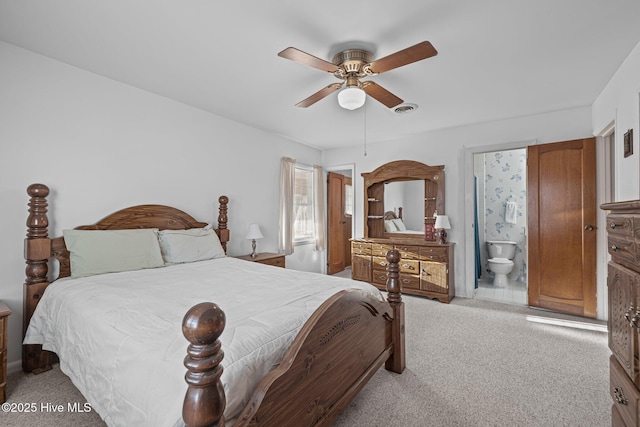 bedroom with a ceiling fan, light carpet, visible vents, and ensuite bathroom