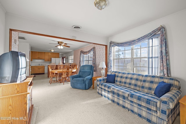 carpeted living room featuring a ceiling fan and visible vents