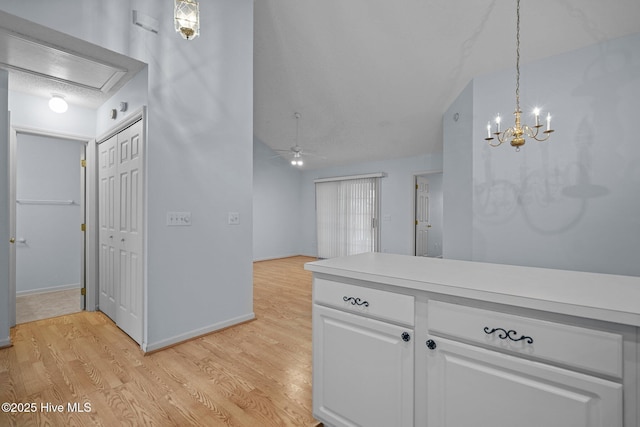 kitchen featuring white cabinetry, hanging light fixtures, ceiling fan, and light hardwood / wood-style flooring