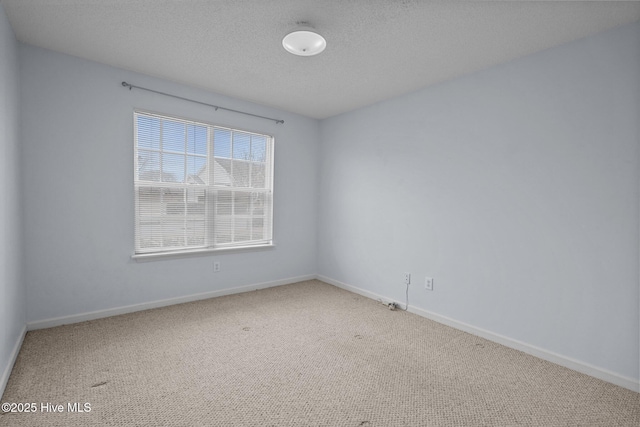 unfurnished room with carpet flooring and a textured ceiling