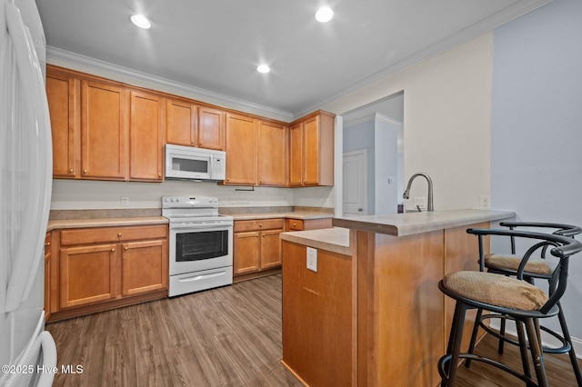225 Adams Ln, Washington, NC 27889 - kitchen with white appliances, a breakfast bar area, ornamental molding, light countertops, and a peninsula