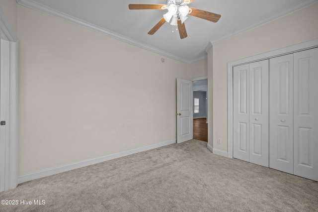 unfurnished bedroom with ornamental molding, light carpet, ceiling fan, and a closet