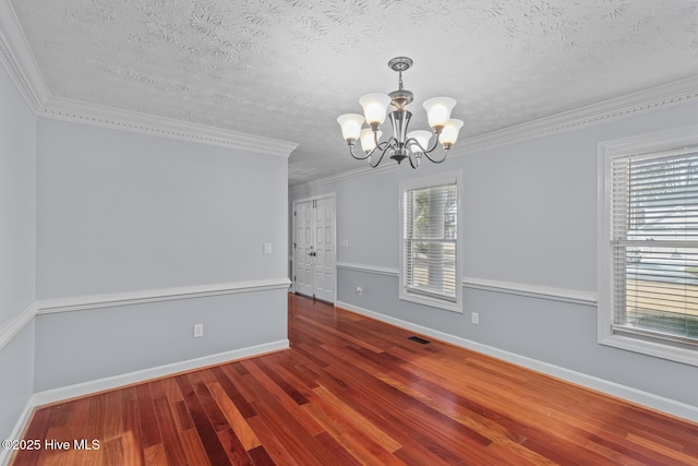 unfurnished room with crown molding, a chandelier, wood-type flooring, and a textured ceiling