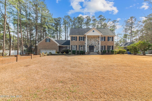 colonial-style house with a front lawn and a garage