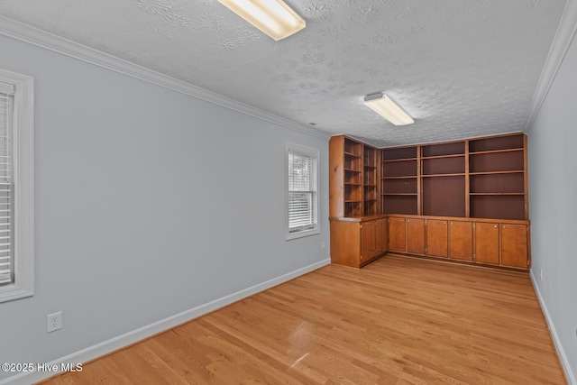 unfurnished room with a textured ceiling, crown molding, and light hardwood / wood-style flooring