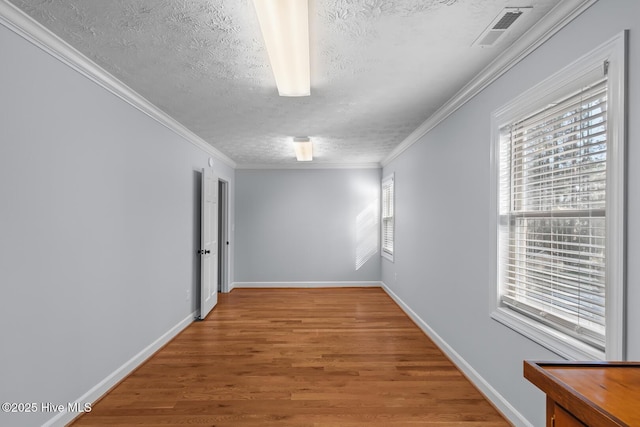 unfurnished room featuring wood-type flooring, crown molding, and a textured ceiling