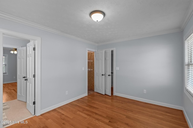 unfurnished room with light wood-type flooring, crown molding, and a healthy amount of sunlight