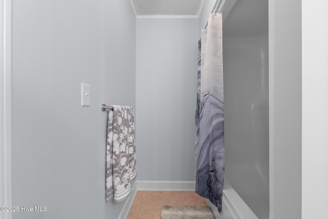 bathroom with a textured ceiling, shower / bath combo with shower curtain, and ornamental molding