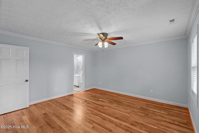 empty room with light hardwood / wood-style floors, crown molding, and a textured ceiling