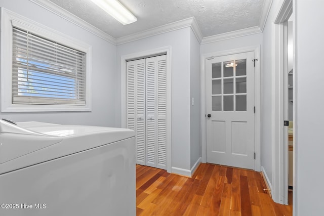 laundry room with ornamental molding, washer / clothes dryer, a textured ceiling, and wood-type flooring