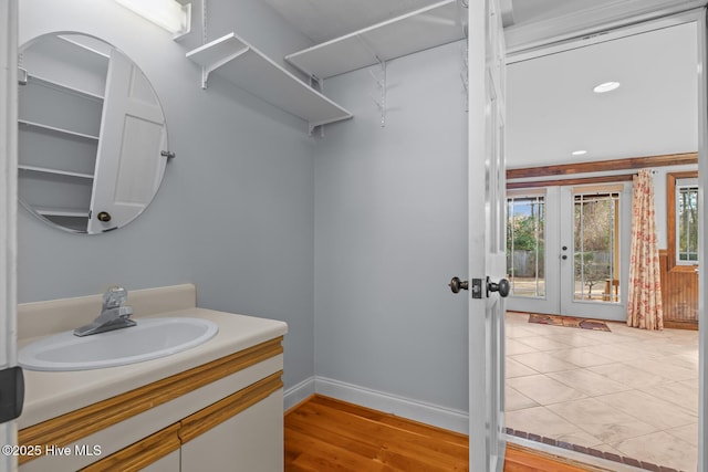 bathroom featuring hardwood / wood-style floors, french doors, and vanity