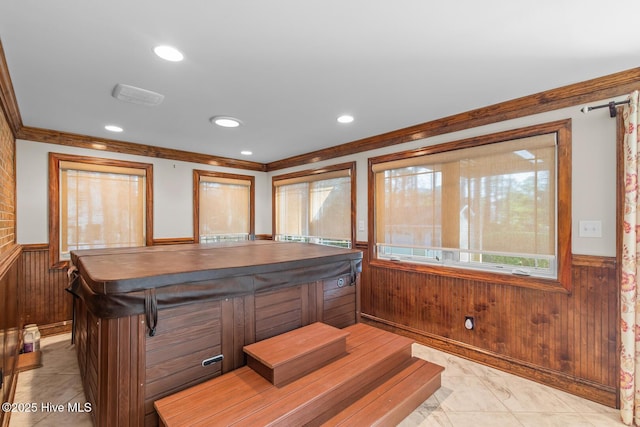 interior space with crown molding and wood walls