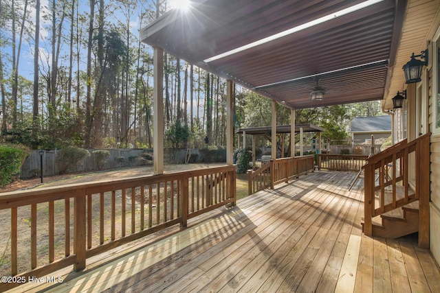 wooden terrace with a gazebo and ceiling fan