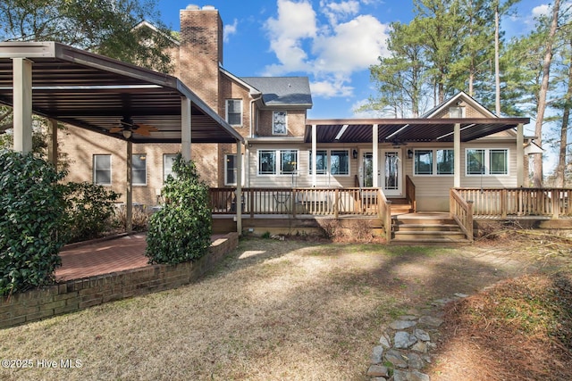 rear view of house featuring a yard, a deck, and ceiling fan