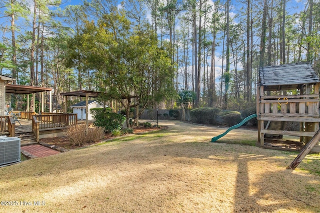 view of yard featuring a shed, central AC, a deck, and a playground