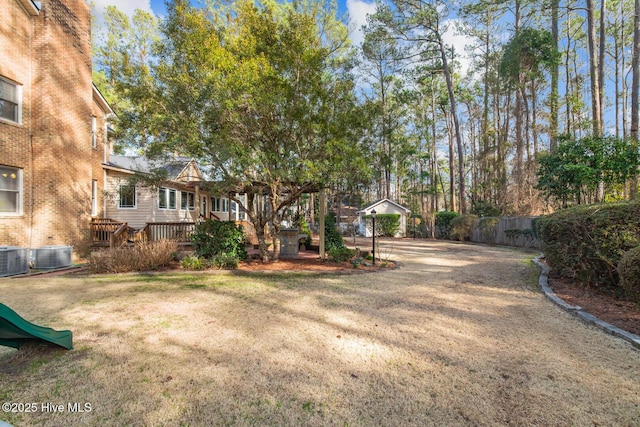 view of yard with central AC unit, a deck, and a pergola