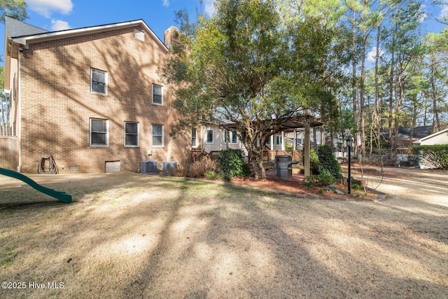 rear view of property with a yard, a pergola, and a playground