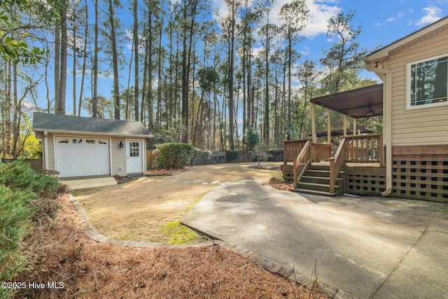 view of yard with an outbuilding, a deck, and a garage