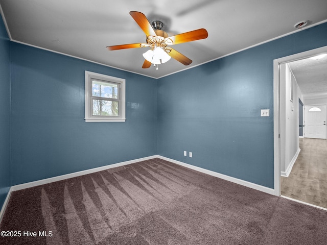 empty room with a ceiling fan, baseboards, and carpet